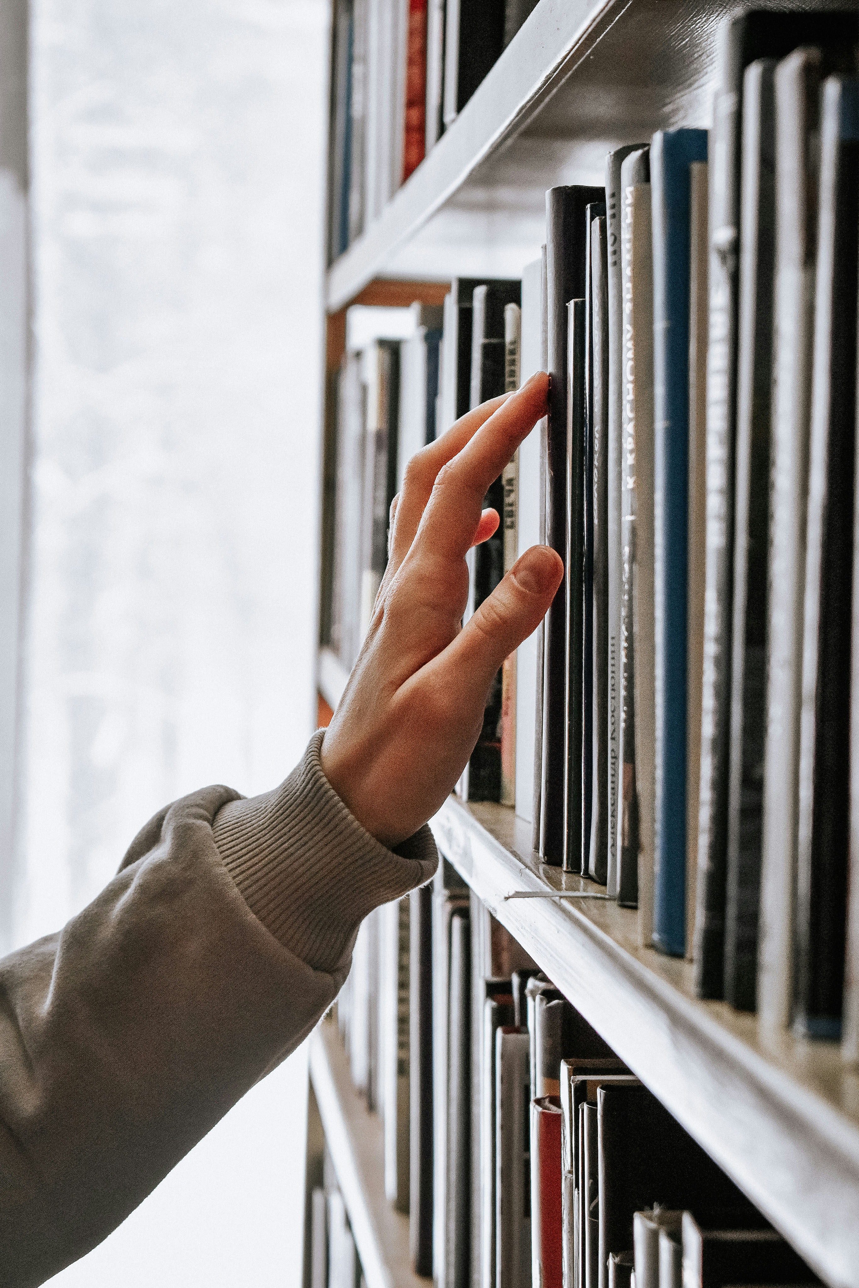 A hand browsing a library shelf. Browse virtual issues from Edinburgh University Press.